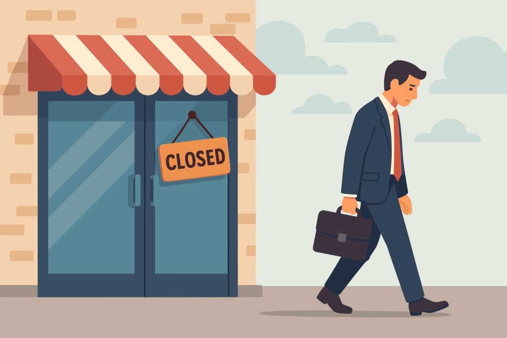 A man in a suit carrying a briefcase walks away sadly from a storefront with a "Closed" sign hanging on the door. The building has glass doors and a red-striped awning.