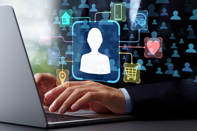 Person typing on a laptop with a digital overlay showing an avatar icon, highlighting how Digital Persona Bias can influence online activities like shopping, email, navigation, home, and health.