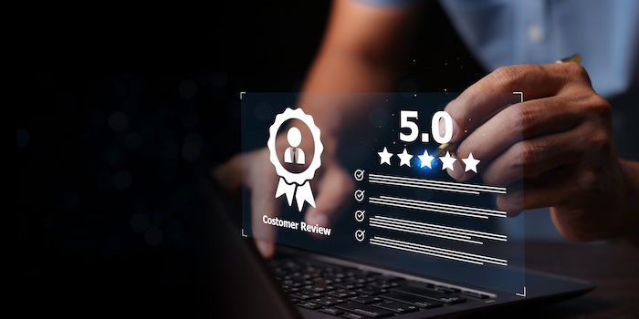 A person interacts with a virtual customer review display showcasing good review examples, including a 5-star rating, checklist items, and a badge icon above a laptop keyboard.