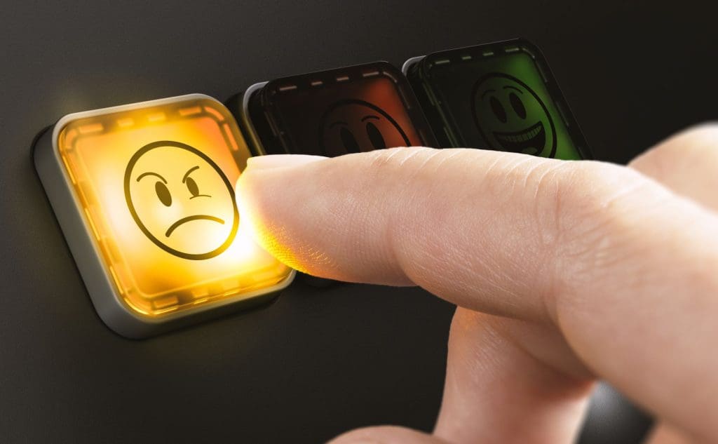 A person leaving a bad review by clicking on an angry face button.