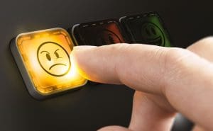 A person leaving a bad review by clicking on an angry face button.