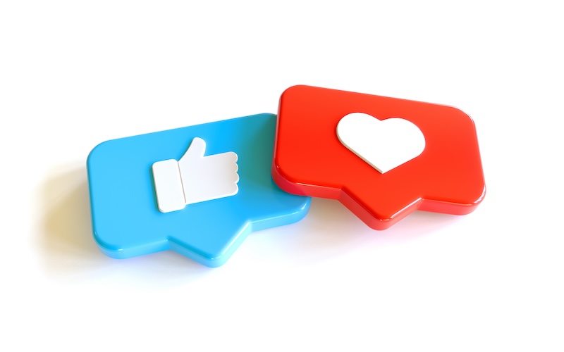 Two 3D speech bubbles on a white background—one blue with a thumbs-up and one red with a heart icon—symbolize how social media likes and favorites help keep a good reputation online.