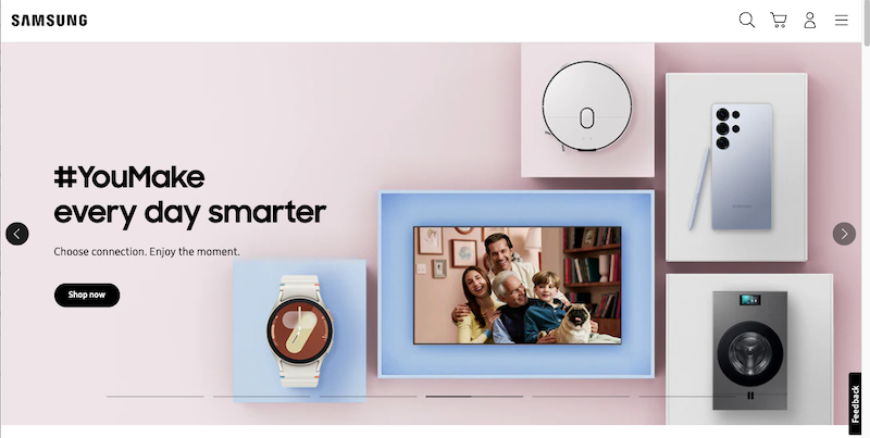 Samsung homepage from the most trusted company, featuring the slogan "#YouMake every day smarter" and images of a smartwatch, robot vacuum, smartphone, TV showing a family, and washer. Enjoy minimalist design and a "Shop now" button.