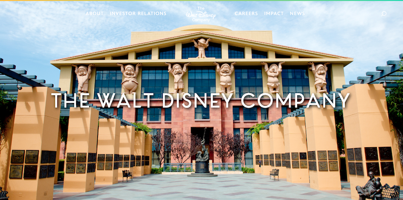 The Walt Disney Company headquarters building, home of the most trusted company, features large character statues on its facade, cream and peach columns, and "The Walt Disney Company" text centered in front.